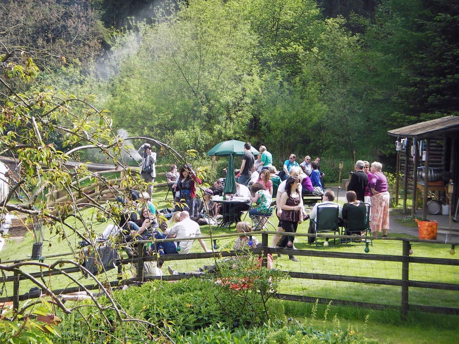 A gathering of people having an outdoor party in the sun. Location marquee, Marthrown of Mabie