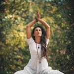 A woman meditating outdoors in a forest setting, embracing tranquility.